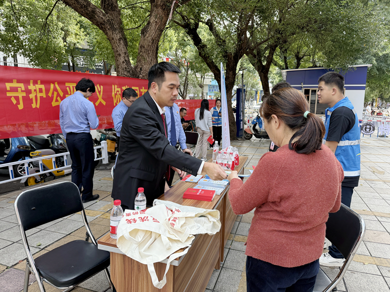 12.为群众发放法治资料。（岑永芳 摄）_副本_副本.jpg